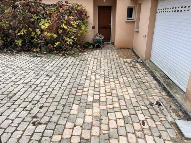 Tranchée remblayée, caniveau et pavés de la cour reposés devant le garage.