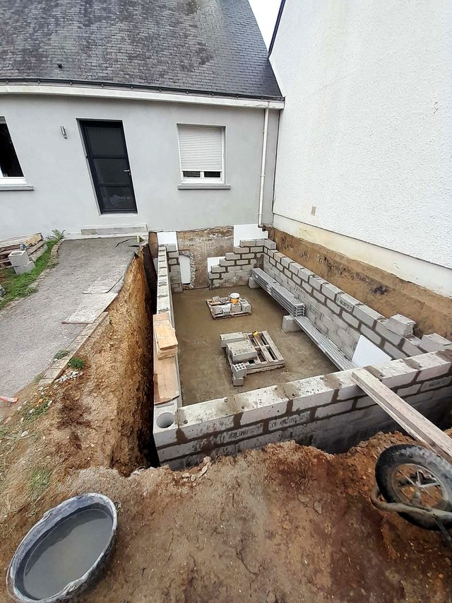 Le sous-sol en cours d’élévation : le terrassement s’arrête au bord de l’allée, pour laisser l’accès à la maison.