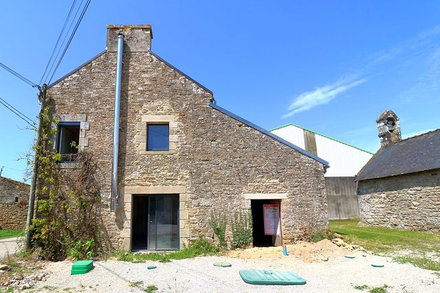 Rénovation d’une maison en pierre : création d’une dalle et de percements, pose des réseaux et d’un drain contre l’humidité.